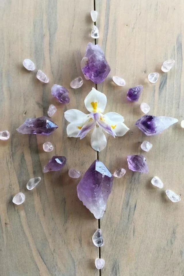 Mandala de amatistas, perlas y una orquídea sobre madera