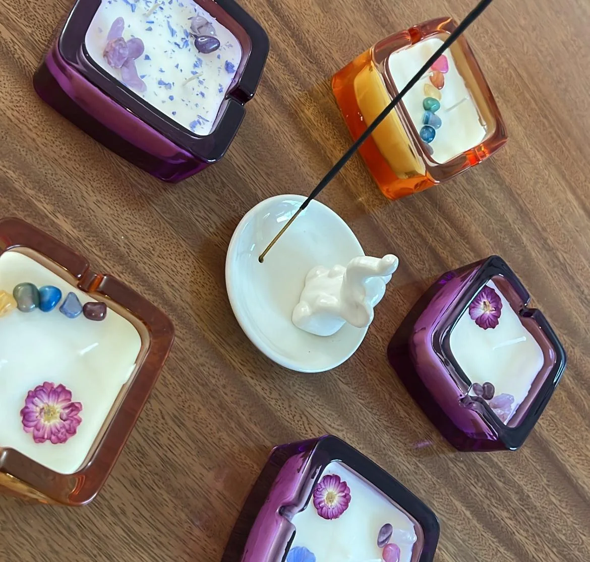 Varias velas Retro cuadradas de vidrio morado y ámbar sobre una mesa